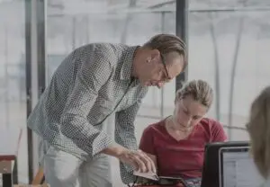 Man talking to woman with a book in his hand