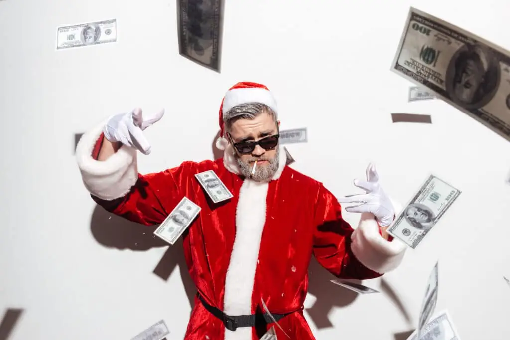 Stylish santa claus in sunglasses smoking and throwing money in the air