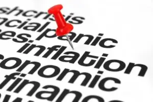 Red pushpin on the word "inflation" in a list of US economic-related problems.