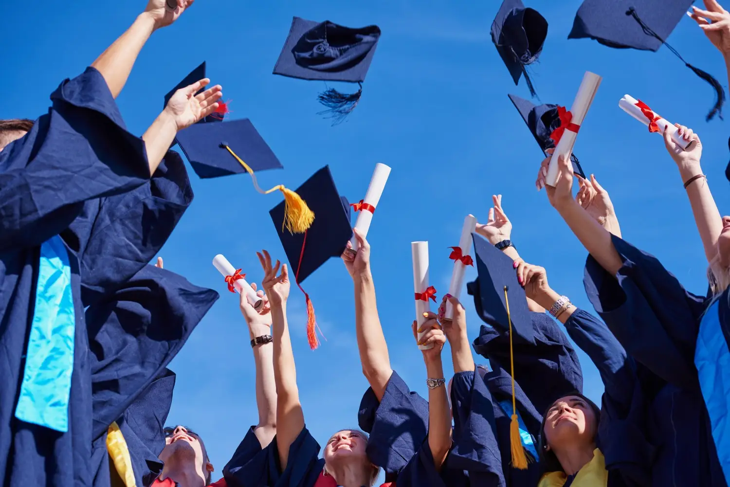 Graduates in caps and gowns celebrate the culmination of their higher education by throwing their caps into the air.