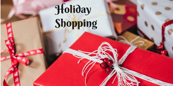 Several wrapped gifts in red, white, and gold paper, adorned with festive ribbons and decorations, are masterfully stacked with "Holiday Shopping" elegantly written above them.