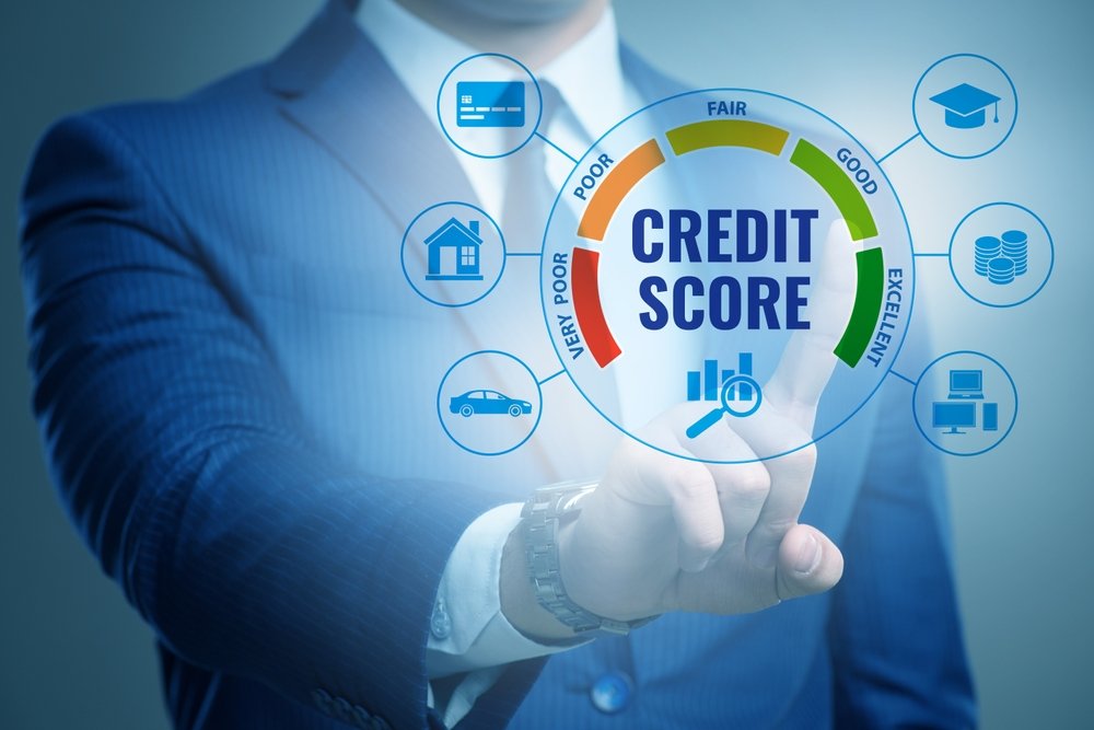 A person in a suit points to a virtual screen displaying a credit score gauge and icons for home, car, graduation cap, and money—perfect for illustrating credit score 101 concepts.