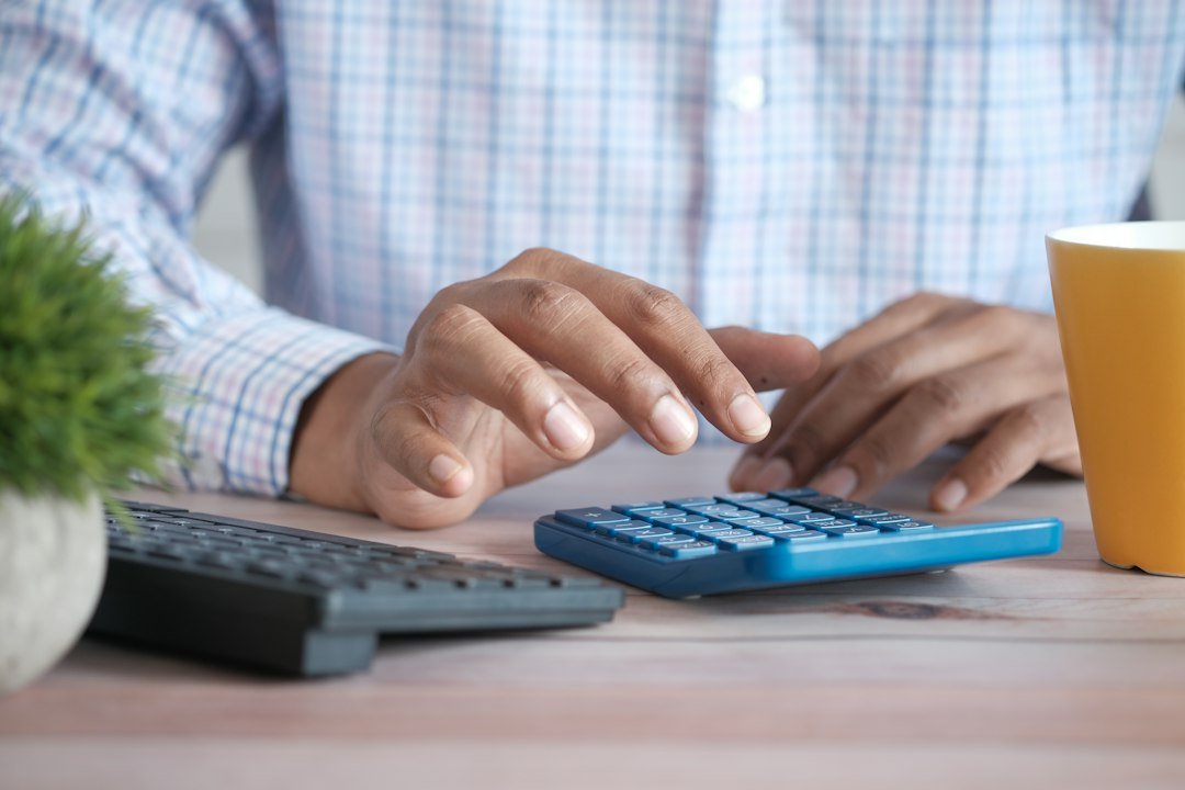 Income in Retirement: a hand using a calculator to review household expenses